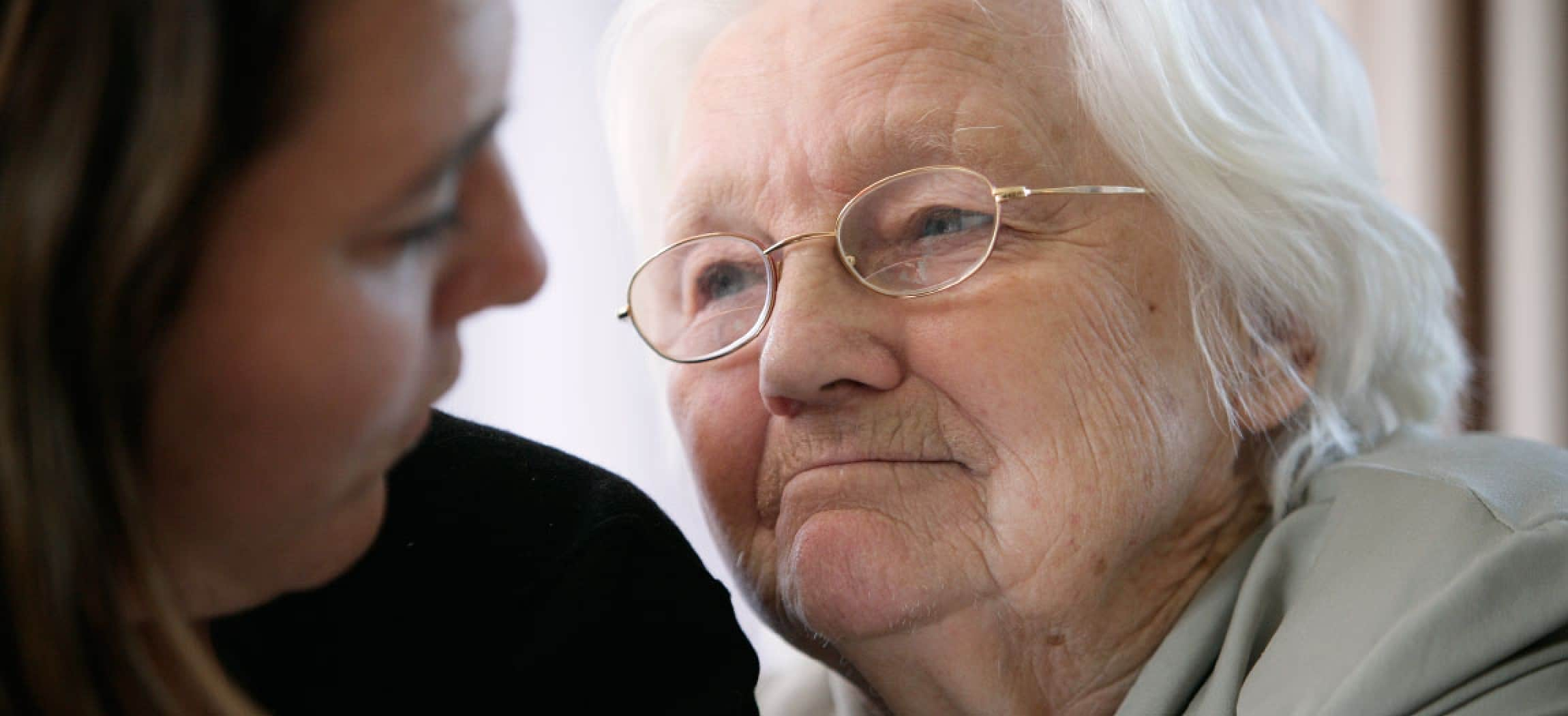 Innig portret van oude vrouw grijs haar met bril en haar dochter