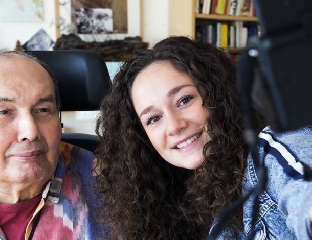 Vlogger Gisette met leuke oudere man kijken in de camera tijdens het vloggen voor Amstelring